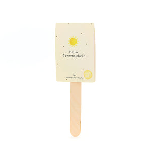 Bâton en bois avec une carte jaune sur laquelle est écrit « Hello Sunshine » et avec un soleil dessus.
