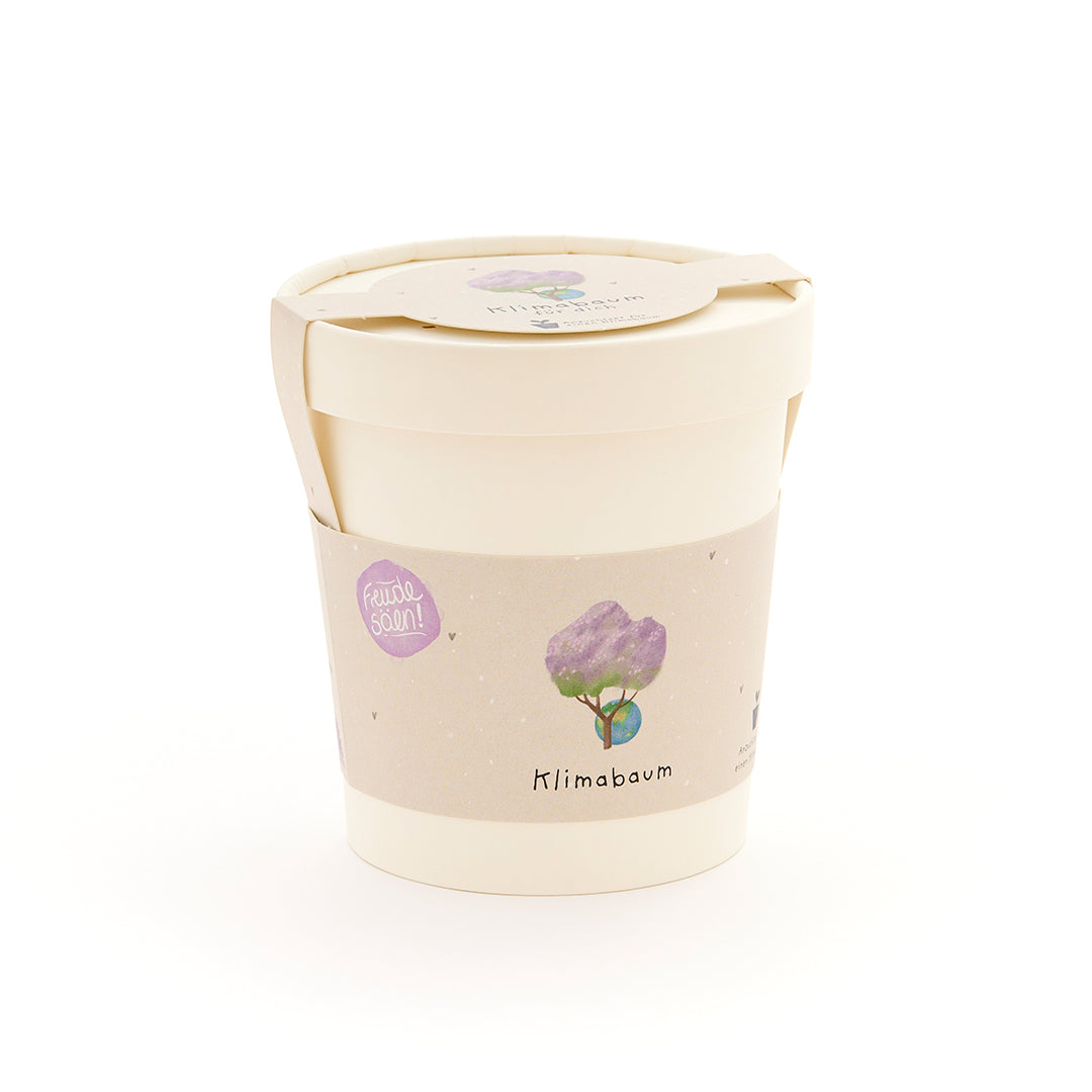 Pot de fleurs beige avec une étiquette représentant un arbre dessiné et les mots « Arbre climatique ».