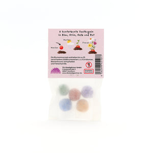 Sachet contenant cinq boules de graines colorées en bleu, vert, jaune et rouge, texte d'emballage en allemand.