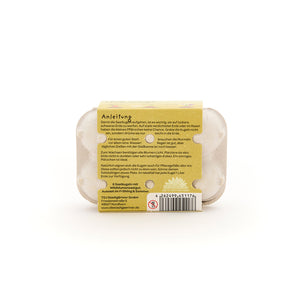 Dos d'une petite boîte à œufs avec instructions jointes pour semer des graines, code-barres et informations sur le fabricant en allemand.