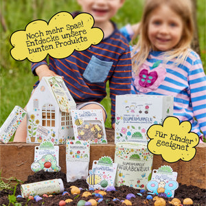 Deux enfants souriants à l'extérieur avec des publicités pour des produits de jardinage colorés et des sachets de graines pour enfants.
