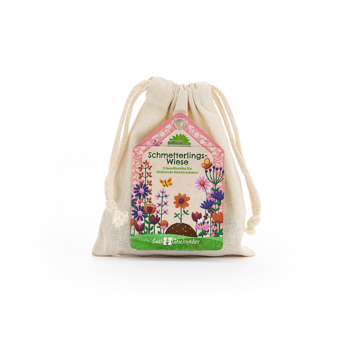 Sac en tissu beige avec une étiquette colorée représentant "prairie aux papillons" et une prairie fleurie.