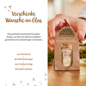 Personne tenant une petite carte-cadeau avec l'inscription « Wish Fulfiller » et une petite bouteille en verre, entourée de décorations saisonnières et de texte présentant des idées de cadeaux pour diverses occasions.