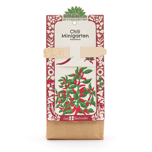 Kit de culture de mini-jardin de piments de Die Stadtgärtner avec motif de plantes rouges et vertes sur l'emballage.