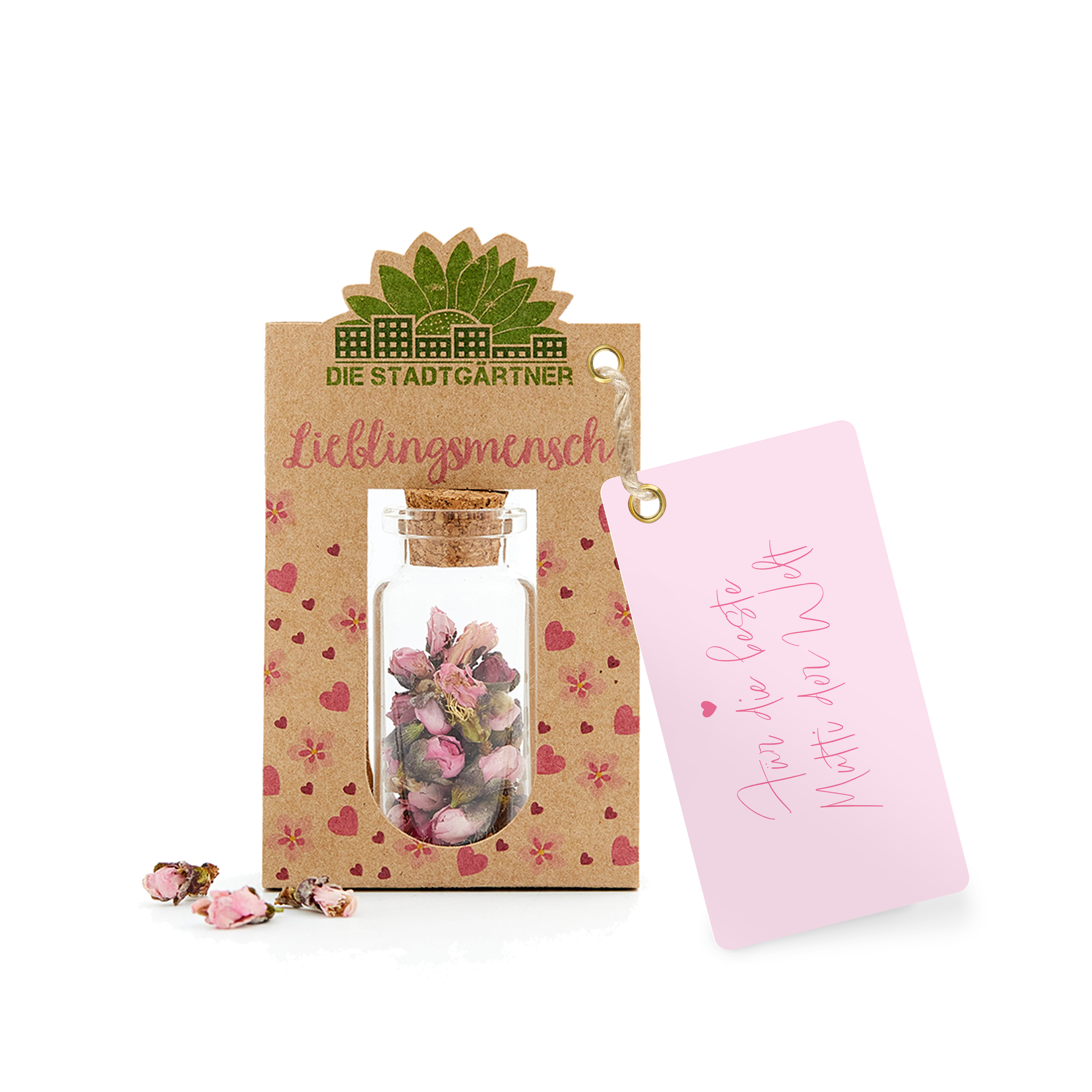 Étiquette cadeau avec l'inscription « Personne préférée » et une petite bouteille en verre avec des fleurs séchées sur un fond de papier kraft à côté d'une carte rose avec un cœur et « Pour toi ».