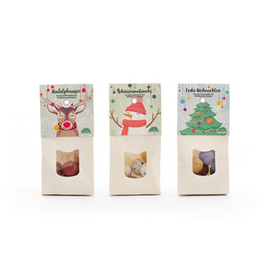 Trois sacs de bonbons de Noël décorés d'illustrations d'un renne, d'un bonhomme de neige et d'un sapin de Noël.