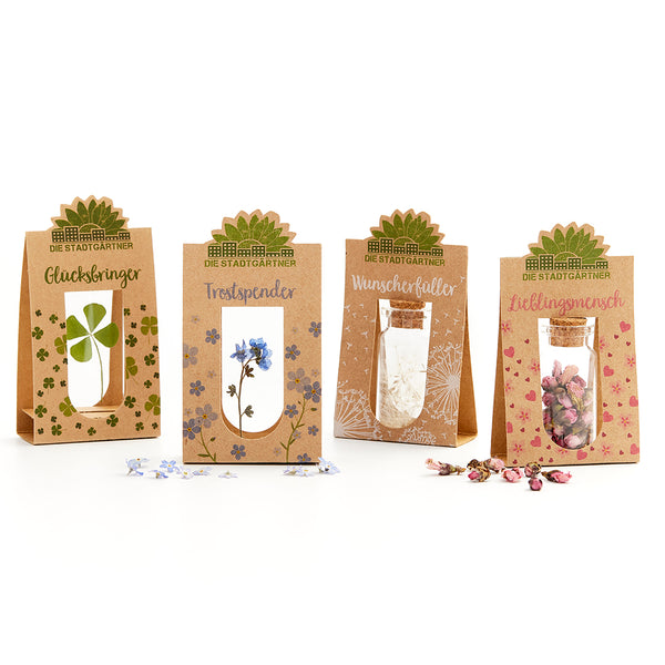 Quatre sacs cadeaux aux motifs naturels et étiquettes : Porte-bonheur, Doudou, Exauceur de vœux, Personne préférée.