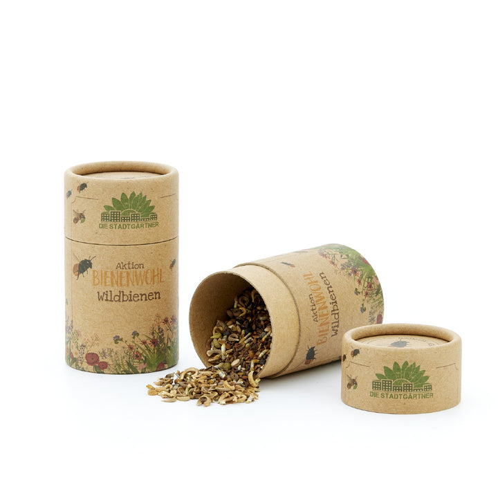 Mélange de graines pour abeilles sauvages versé à partir d'un tube en carton, avec l'étiquette "Aktion BIENENWOHL" (Action BIEN-ÊTRE DES ABEILLES) des "Stadtgärtner" (Jardiniers de la ville).
