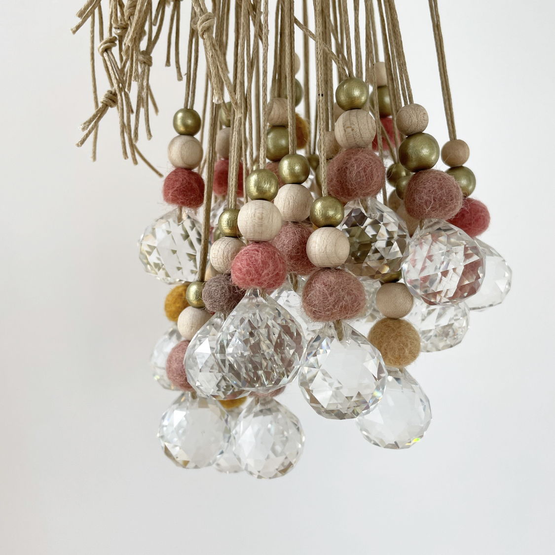 Lustre décoratif avec boules de feutre colorées et cristaux brillants.