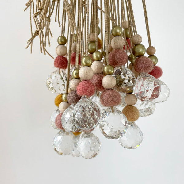 Lustre décoratif avec boules de feutre colorées et cristaux brillants.