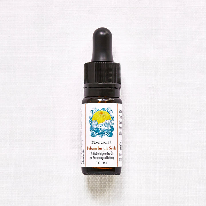 Flacon avec pipette sur fond clair, étiquette indiquant « Baume pour l'âme de Niendorf, huile anti-stress pour égayer l'humeur, 10 ml ».