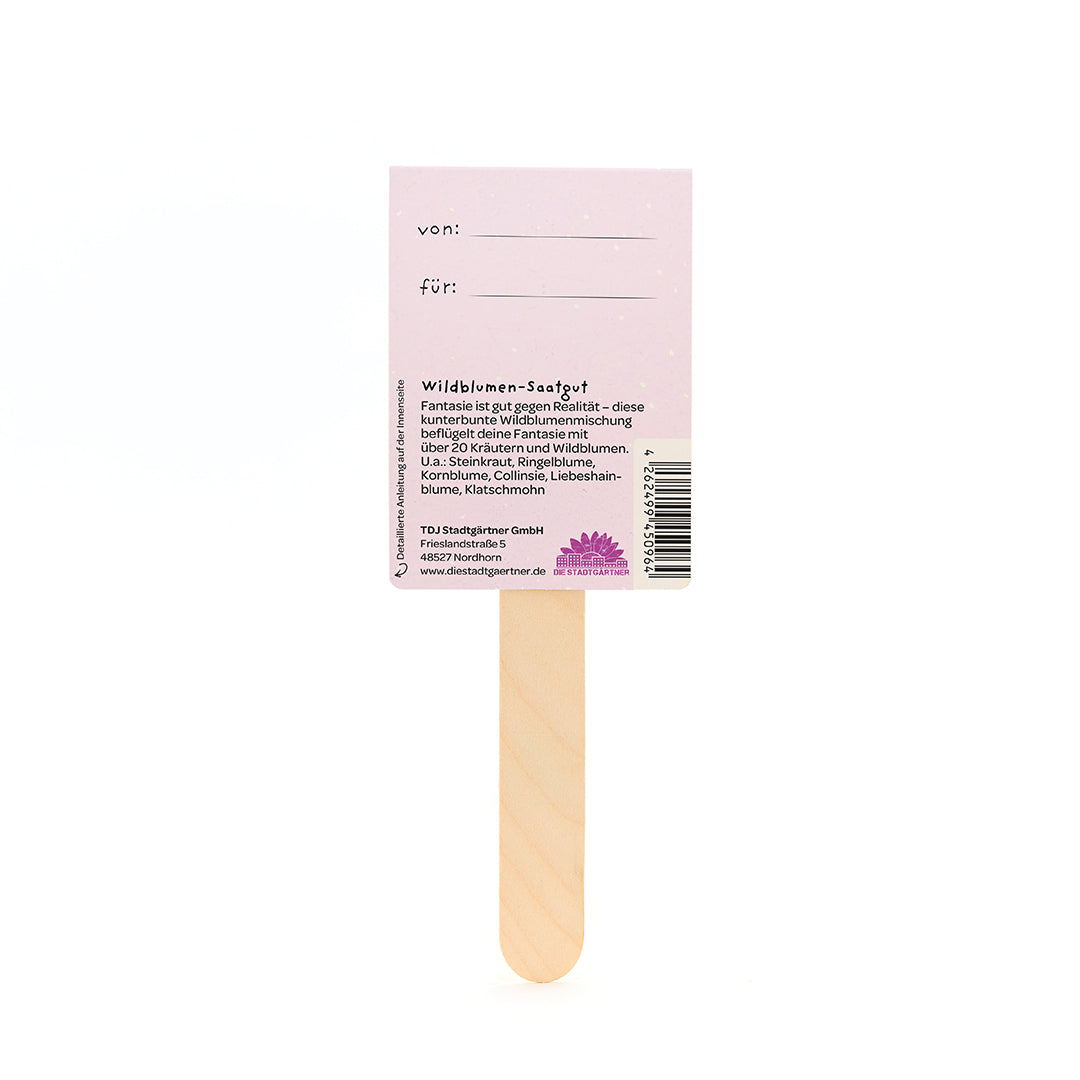 Bâtonnets en bois avec une étiquette rose sur laquelle sont inscrits « von » et « für » et qui fournit des informations sur les graines de fleurs sauvages en allemand.