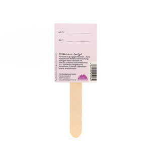 Bâtonnets en bois avec une étiquette rose sur laquelle sont inscrits « von » et « für » et qui fournit des informations sur les graines de fleurs sauvages en allemand.