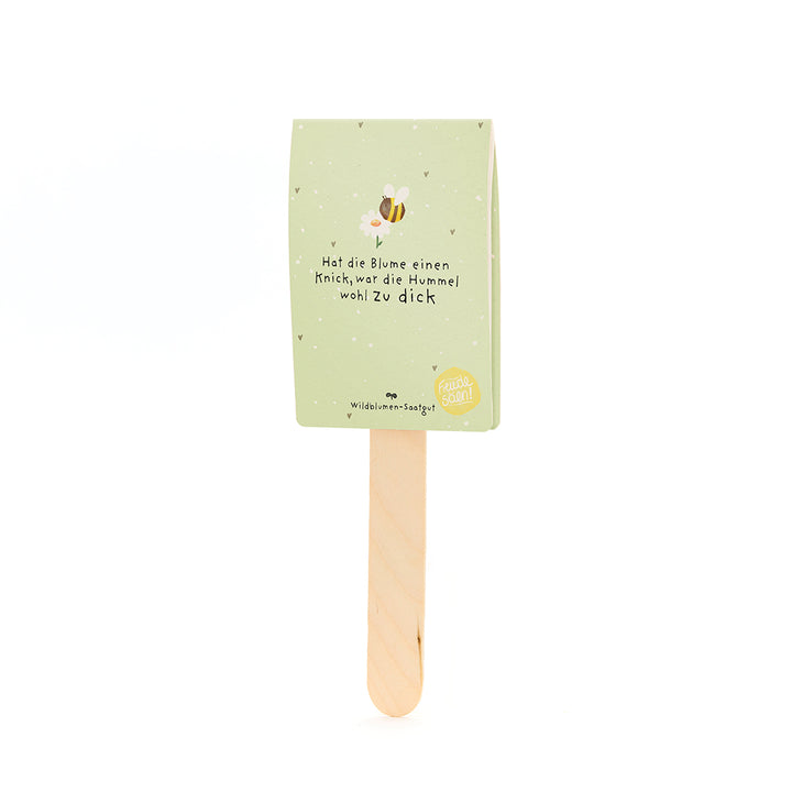 Étiquette en papier vert avec un motif d'abeille et l'inscription « Si la fleur a un pli, le bourdon était probablement trop gros » sur un bâton en bois.