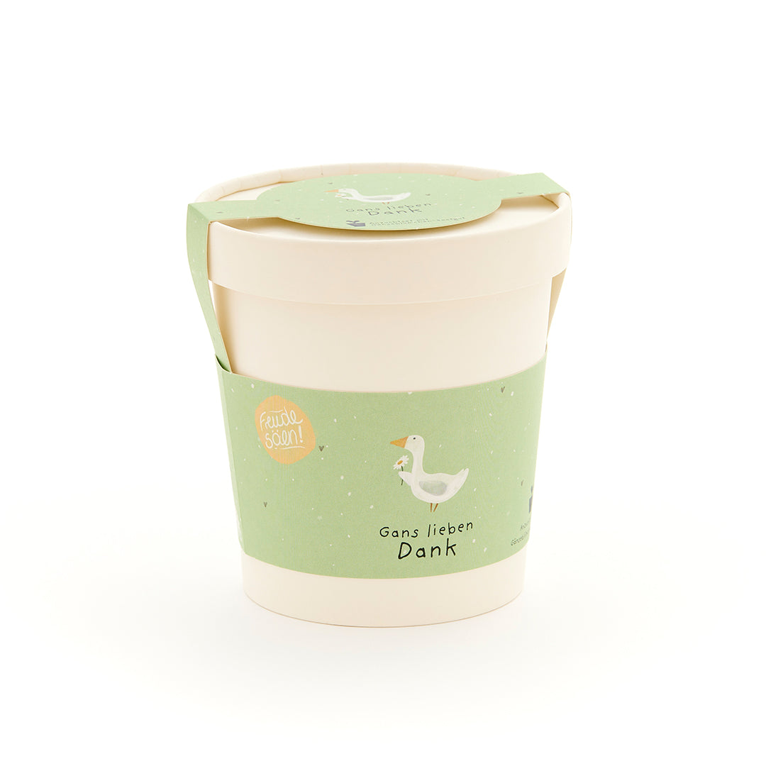 Mug beige avec une étiquette verte comportant un dessin d'oie et le texte « Merci beaucoup, Goose ».