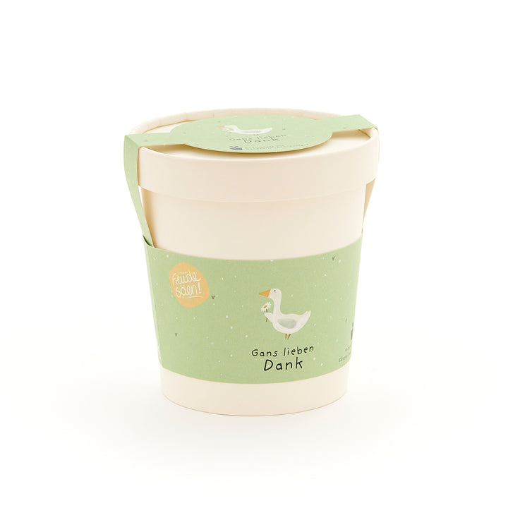 Mug beige avec une étiquette verte comportant un dessin d'oie et le texte « Merci beaucoup, Goose ».