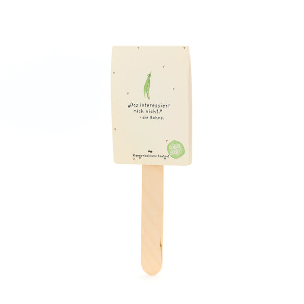 Une tige avec un emballage dessus, étiqueté « Je ne suis pas intéressé par ça. - le haricot », avec un dessin d'un haricot vert en dessous, pour les graines de haricot coureur.