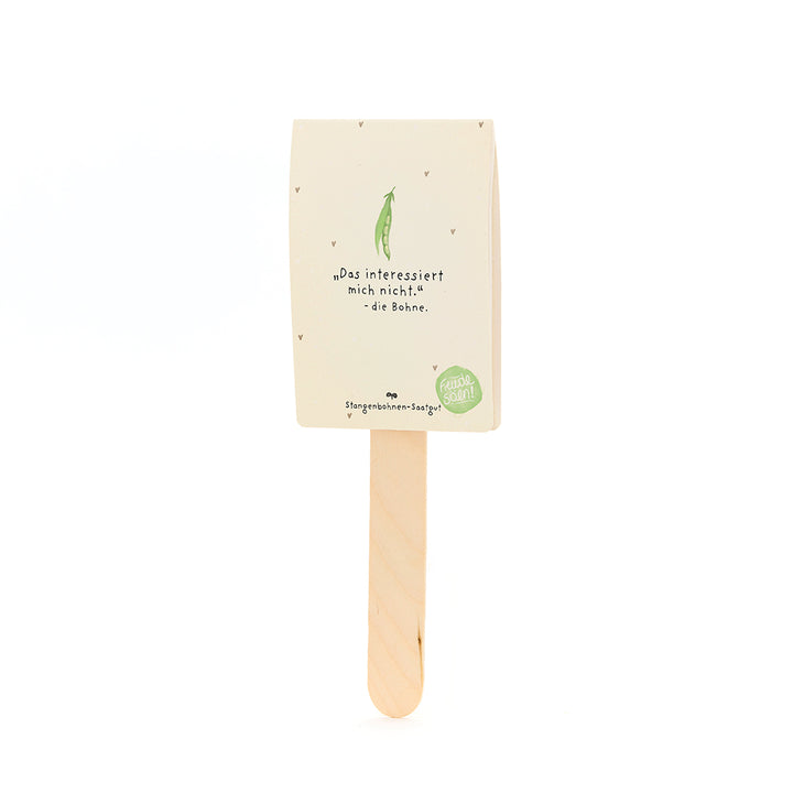 Une tige avec un emballage dessus, étiqueté « Je ne suis pas intéressé par ça. - le haricot », avec un dessin d'un haricot vert en dessous, pour les graines de haricot coureur.