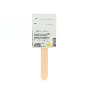 Dos d'un sachet de graines avec un bâtonnet en bois contenant des informations sur les graines de fleurs sauvages et un espace pour « de : » et « pour : ».