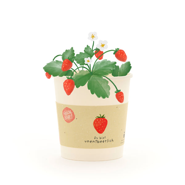 Un pot de fleurs de couleur crème avec un dessin d'un fraisier, de fraises rouges et de fleurs blanches, ainsi que l'inscription « Vous êtes indispensable ».