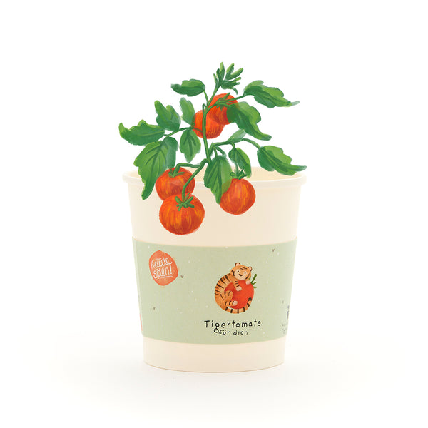 Tasse avec un petit plant de tomate, l'étiquette dit « Tomate tigre pour vous » et montre un dessin d'un tigre avec une tomate.