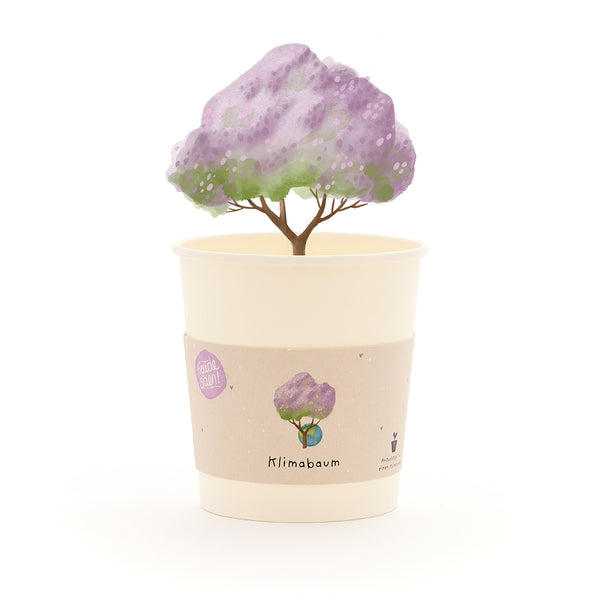 Tasse avec un arbre dessiné aux feuilles violettes et les mots « Climate Tree » sur l'étiquette.