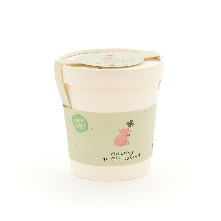 Tasse avec une étiquette verte représentant un cochon avec une feuille de trèfle et l'inscription « Bonne chance, enfant chanceux ».