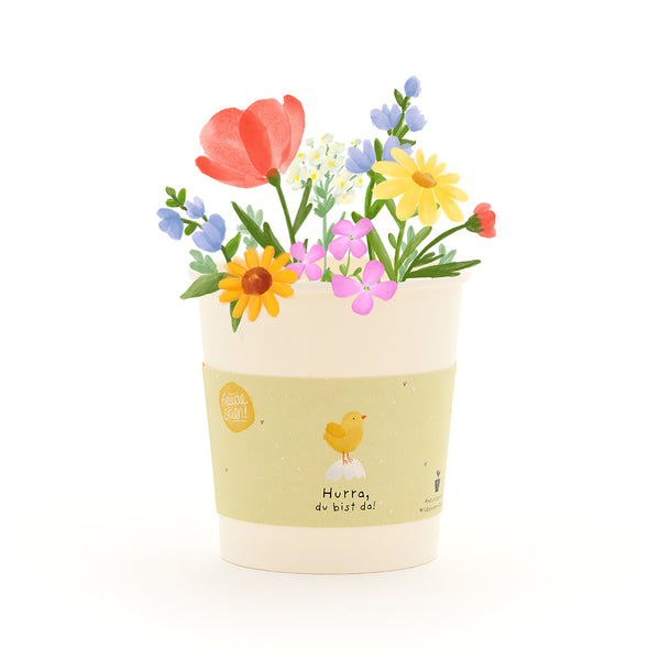 Pot de fleurs illustré avec des fleurs colorées et une étiquette jaune représentant un poussin et le texte « Hourra, vous êtes là ! »