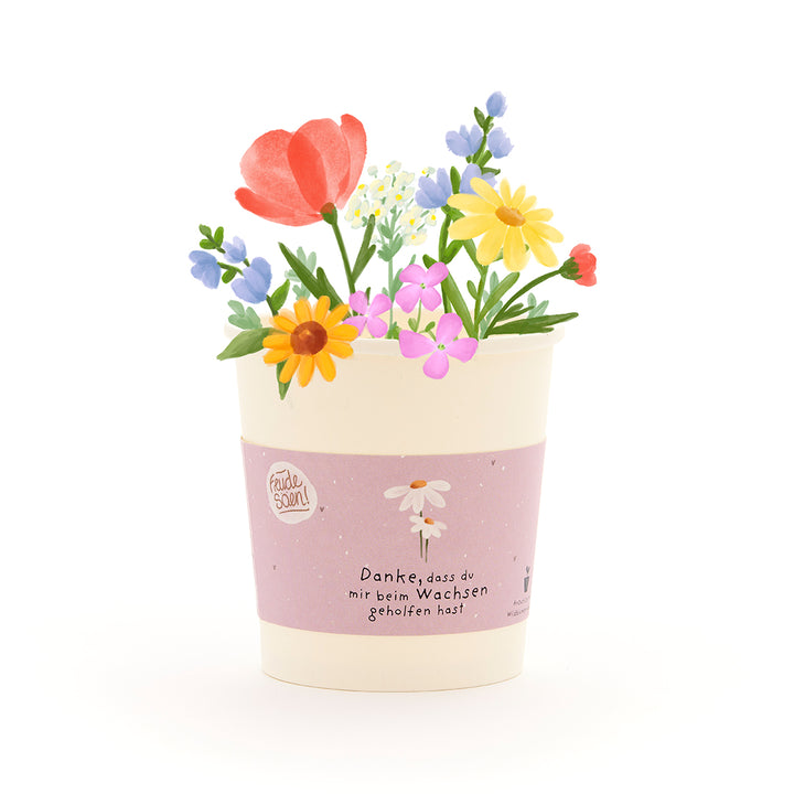 Un pot de fleurs avec des fleurs colorées et dessinées et un ruban sur lequel est écrit : « Merci de m'aider à grandir. »