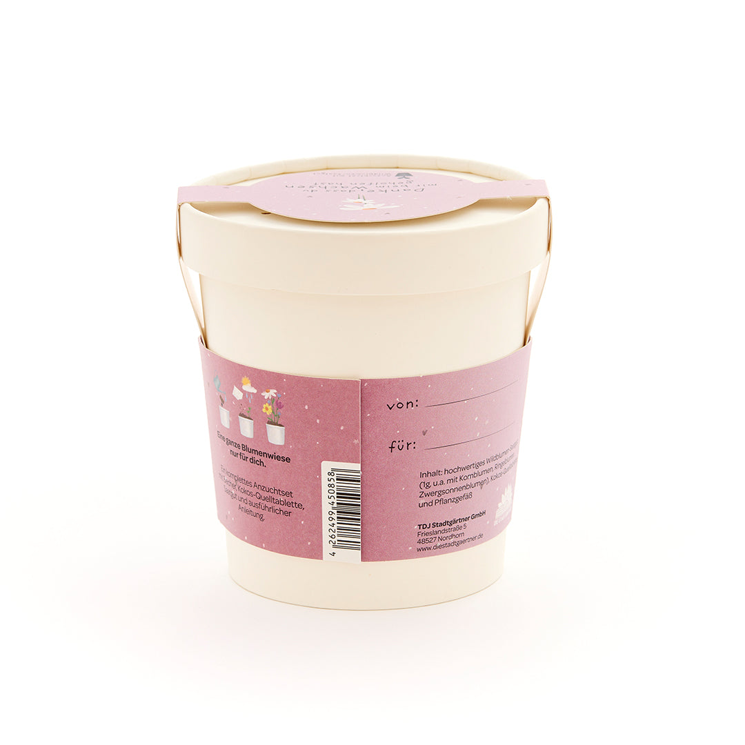 Pot de fleurs beige avec une étiquette rose contenant des informations et un espace pour « de » et « pour ».
