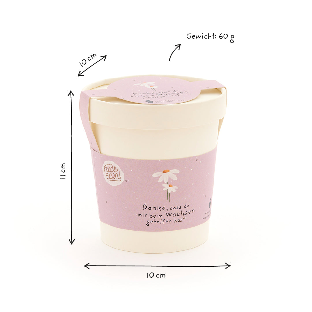Mug avec une banderole violette, un motif de marguerite et l'inscription "Merci de m'avoir aidé à grandir", à côté les dimensions (10 cm x 10 cm x 11 cm) et le poids (60 g).