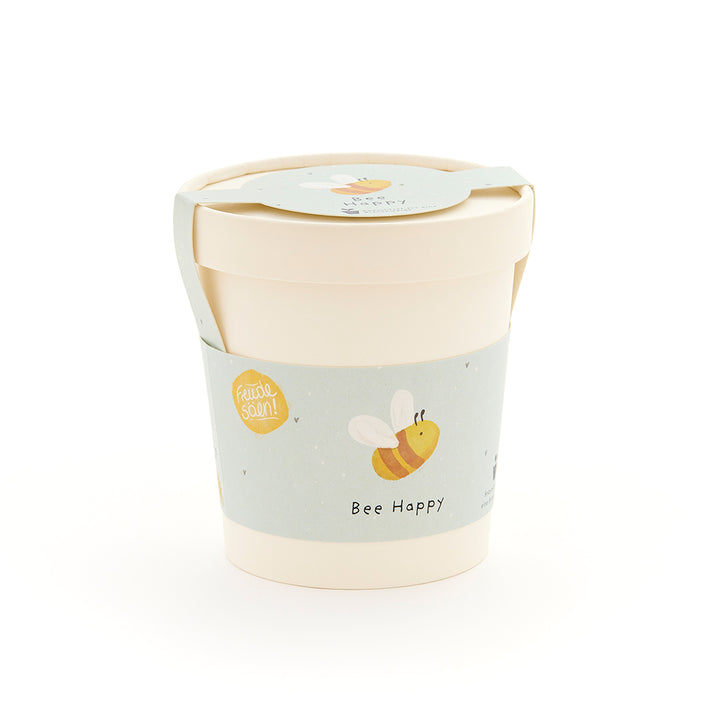 Mug beige avec une étiquette bleu clair représentant une abeille dessinée et les mots « Bee Happy ».