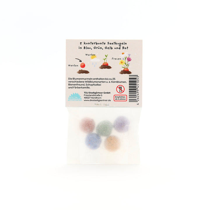 Cinq boules de graines colorées dans un emballage transparent avec des instructions étiquetées en allemand.