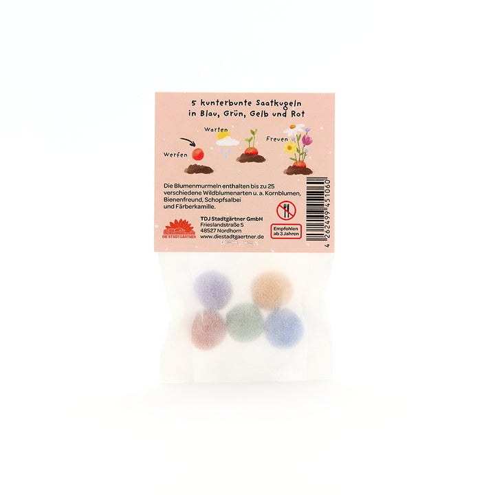 Un sac contenant cinq boules de graines colorées en bleu, vert, jaune et rouge, ainsi que des instructions et des informations au dos de l'emballage.