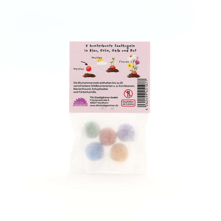 Sachet contenant cinq boules de graines colorées en bleu, vert, jaune et rouge, texte d'emballage en allemand.