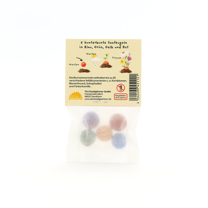 Cinq boules de graines colorées dans un emballage transparent avec une étiquette jaune et une description en allemand.