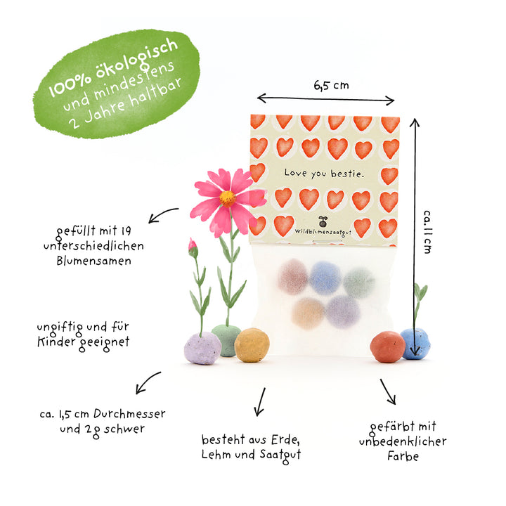 Un paquet de boules de graines colorées dans un sac à motifs de cœur avec les mots « Love you bestie », entouré d'un texte explicatif expliquant que les boules sont écologiques, non toxiques, adaptées aux enfants et remplies de diverses graines de fleurs.