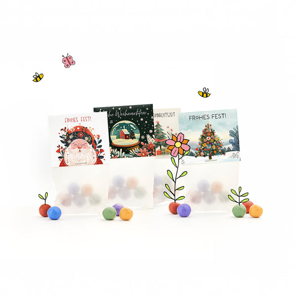 Trois sacs-cadeaux sur le thème de Noël avec des boules colorées, des motifs de Noël illustrés et les mots « Joyeux Noël ! » ainsi que des fleurs dessinées, des abeilles et un papillon.