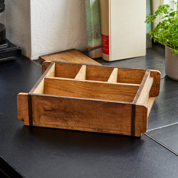 Insert de tiroir en bois à compartiments multiples sur un plan de travail de cuisine noir.