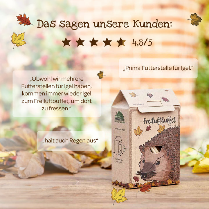 Station d'alimentation en carton avec une illustration de hérisson, des feuilles d'automne et des avis clients sur le produit en allemand.