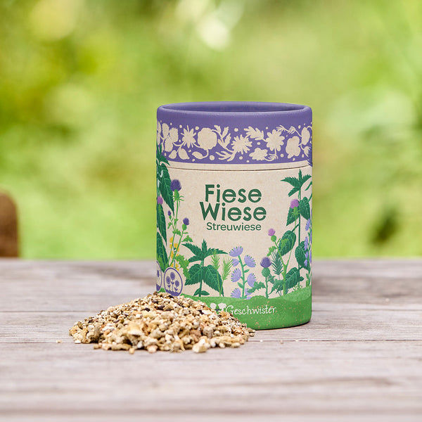 Peut être étiqueté « Fiese Wiese Streuwiese » (Prairie dispersée de Fiese Wiese) avec un mélange de graines sur une table en bois à l'extérieur.