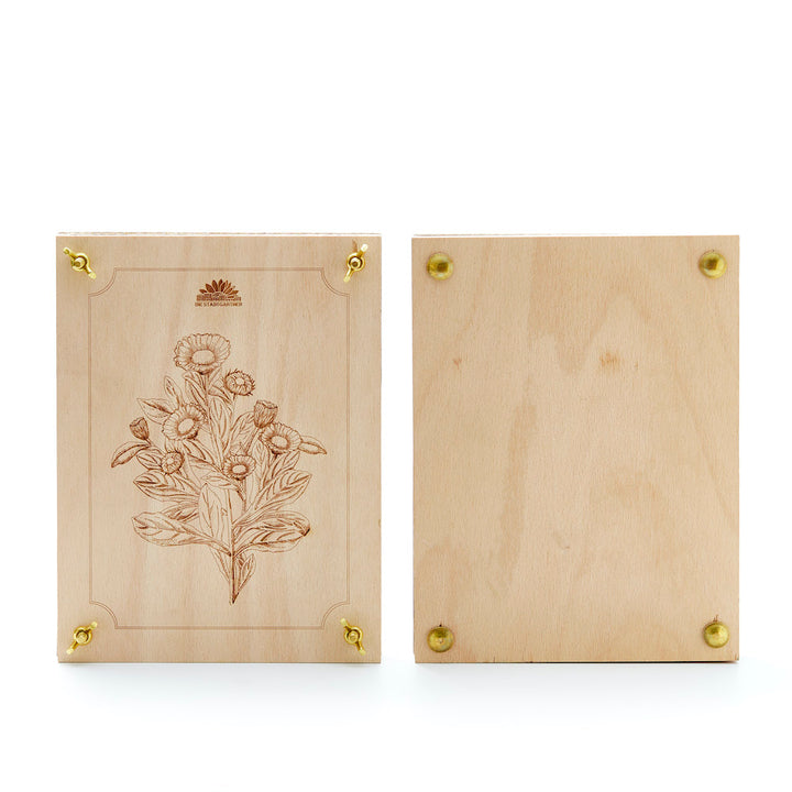 Deux plaques en bois, l'une avec gravure florale et vis en laiton, l'autre non décorée.