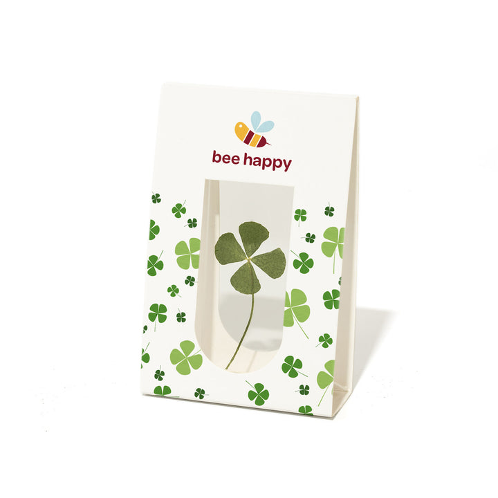 Sac en papier avec un trèfle à quatre feuilles et le texte « bee happy » ainsi qu'une illustration d'abeille.