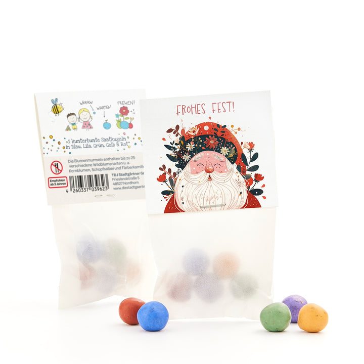 Un sac de boules de graines colorées, devant une carte avec un dessin du Père Noël et les mots « Joyeux Noël ! »