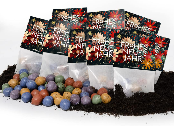 Plusieurs bombes de graines colorées reposent sur le sol devant des sacs portant l'inscription « Bonne année » et un motif floral.