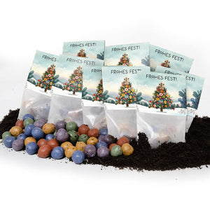 Plusieurs petits sacs avec l'inscription « Joyeuses fêtes ! » et un sapin décoré de Noël, devant lequel se trouvent des boules de graines colorées sur le sol.