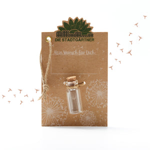 Carte marron avec l'inscription « Les Jardiniers de la Ville », une petite bouteille en verre et des pissenlits illustrés.