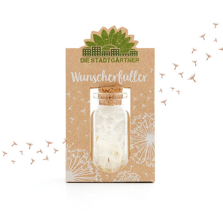 Emballage du produit « Wish Fulfiller » avec une petite bouteille et des graines de pissenlit, entourées d'un motif de pissenlit blanc sur fond marron.