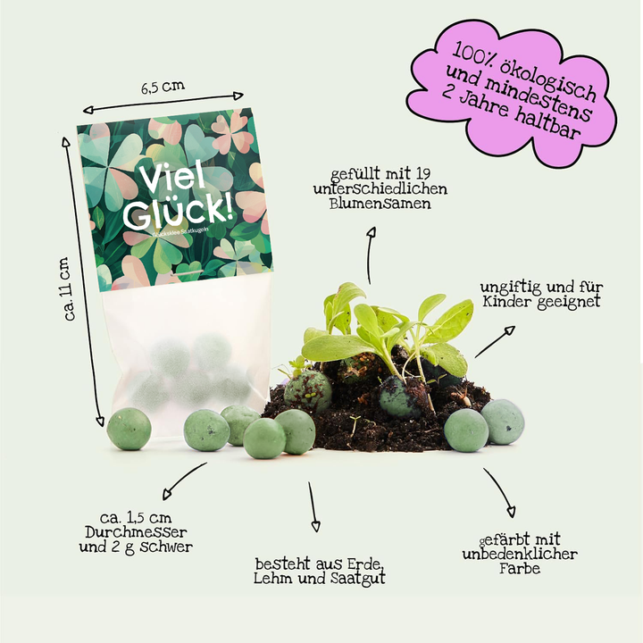 Un sac étiqueté « Bonne chance ! » contient des boules de graines vertes faites de terre, d’argile et de graines biologiques, non toxiques et sans danger pour les enfants ; de petites plantes poussent à partir des boules à côté d’elles.