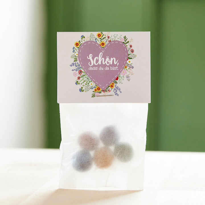 Un sac de bonbons colorés et une carte avec un cœur et les mots « C'est super que tu sois là ».